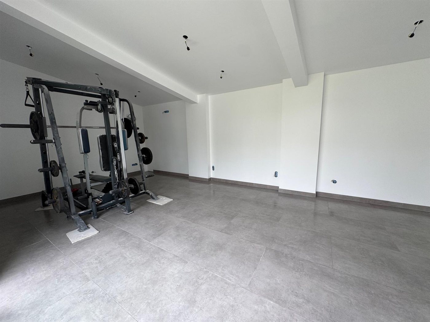 Pièce avec carrelage grand format gris et murs blancs lisses – UA Construction